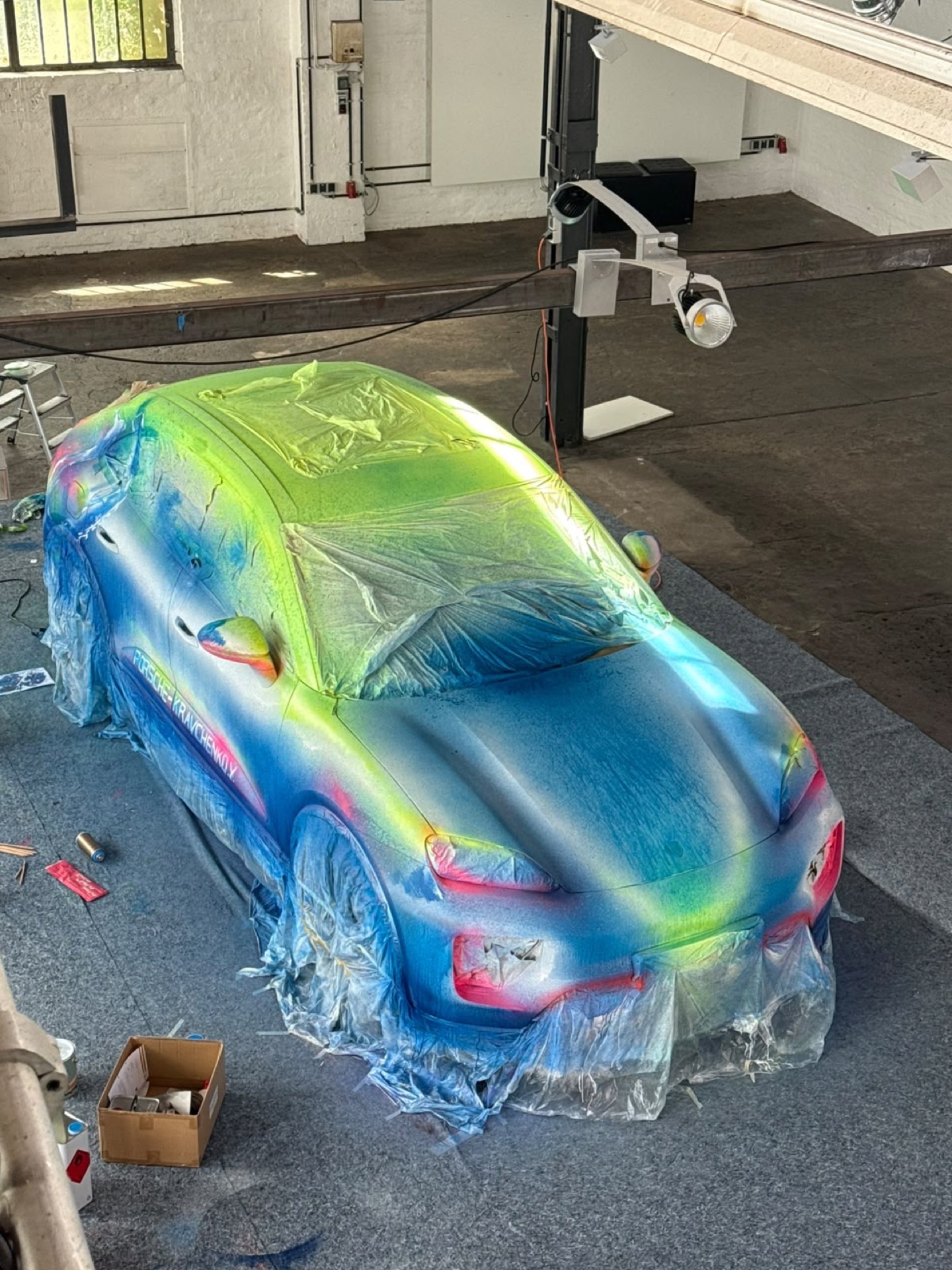 Der Macan von oben während des Farbauftrags in Grün, Blau und Pink