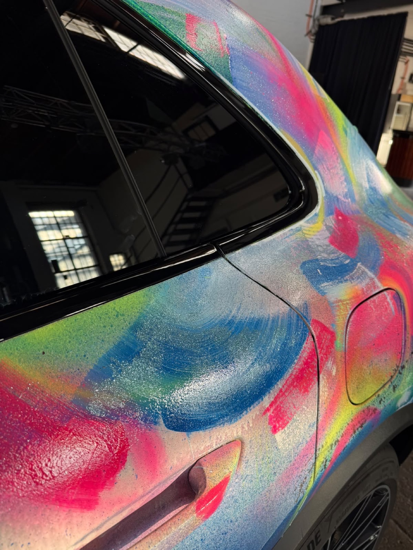 Seitenansicht des bemalten Porsche Macan mit Signatur der Künstlerin am Kotflügel